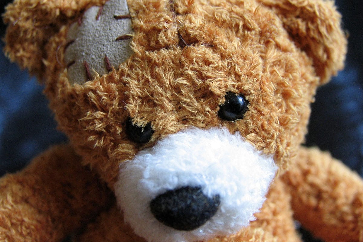 Een teddybeer met een doek op zijn hoofd genaaid