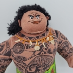 pluche van het karakter Moana Maui uit de disney tekenfilm we zien haar hoofd en haar buste volledig getatoeëerd