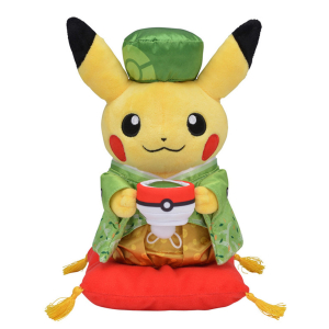 Pikachu pluche die een pokeball vasthoudt en een groene Chinese outfit draagt met een bijpassende hoed en op een klein rood kussen staat